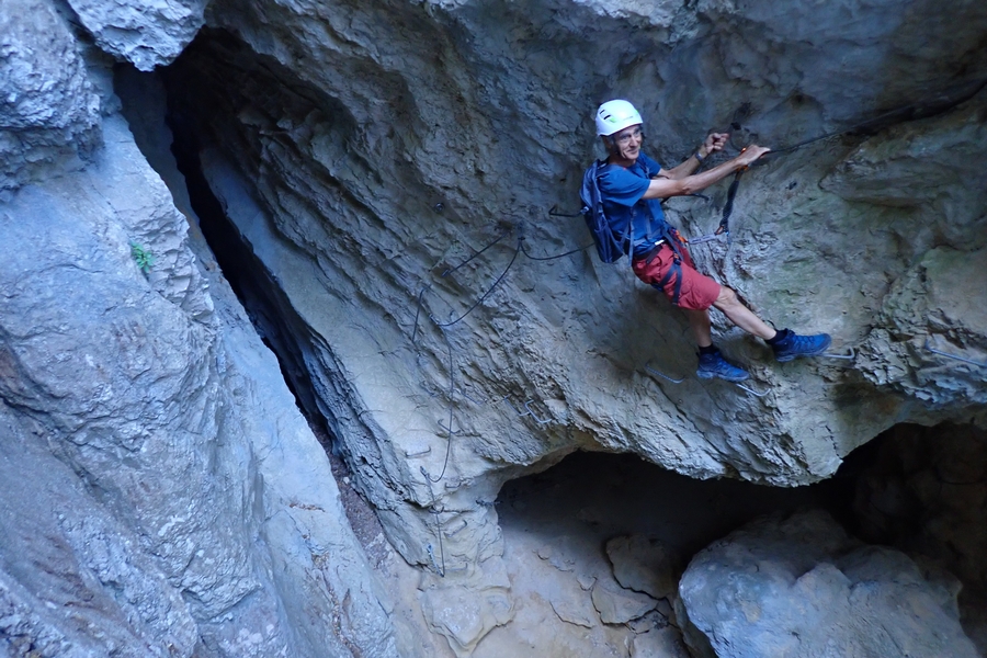 un homme progresse en traversée en s'aidajnt des barreaux et des cables